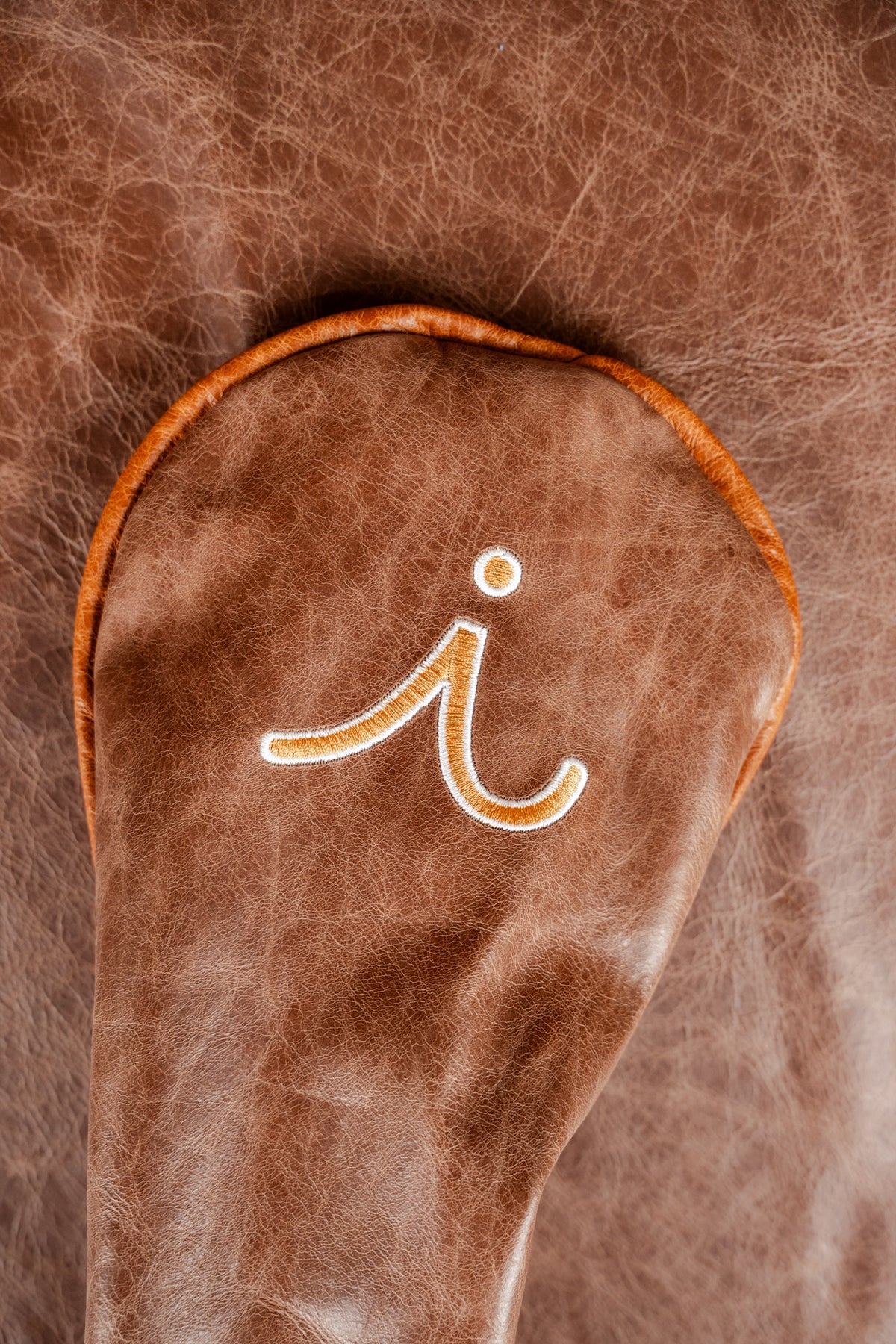 White blade putter cover with orange argyle and a cardinal perched on the toe