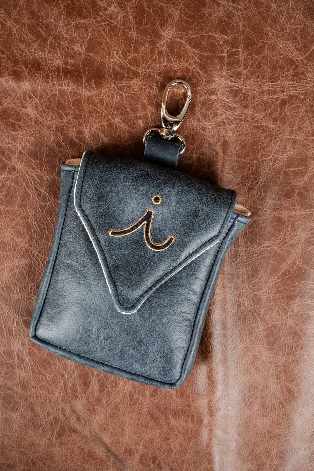 Black and red leather bag hung from a white car door