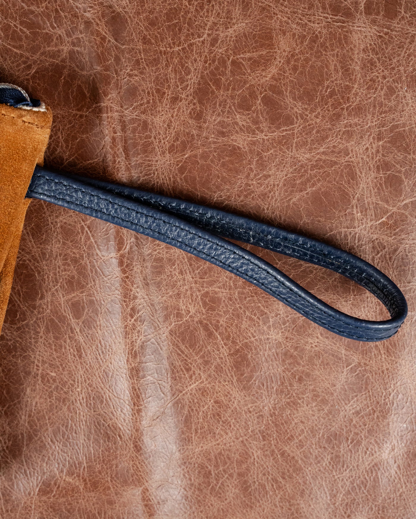 Navy wristlet strap on the iliac Velora Fall Edition clutch